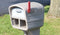 A gray plastic mailbox with the red flag up close up of the top