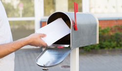 A man putting letters into a mailbox