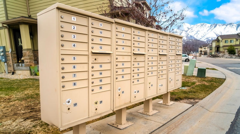 mailboxes with numbered compartments on the side of a road