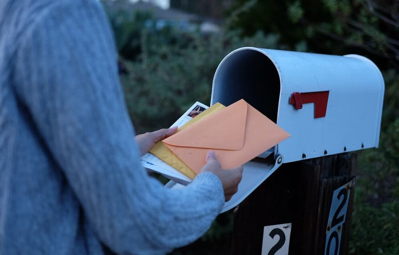 woman collect mails from a mailbox